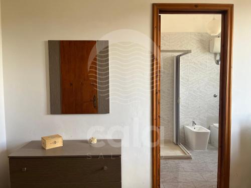 un bagno con lavandino, WC e specchio di Villa Sarah - Spiaggia a 20m By Cala Salento a Isola della Malva