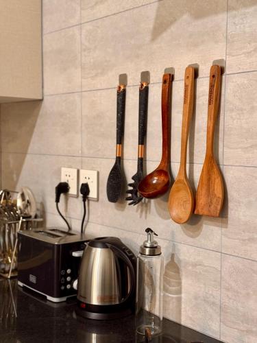 a row of wooden spoons hanging on a wall at Centaurus Apartment Three Bed Mountain View in Islamabad