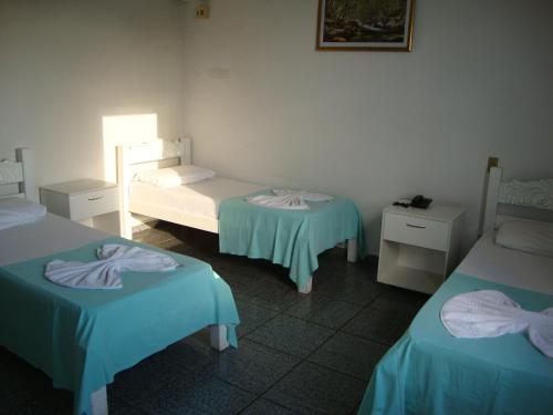 a room with two beds and two tables in it at D'arc Hotel in Goiânia