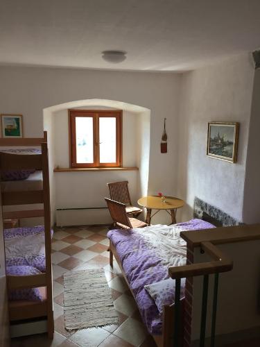 sypialnia z łóżkiem, stołem i oknem w obiekcie Štanjelski Razgledi AR w mieście Štanjel