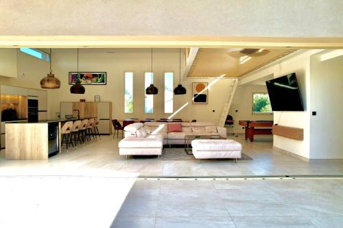 un salon avec un canapé et une salle à manger dans l'établissement L’Étoile de Dan, Piscine, Spa & Jeux, à Crespian