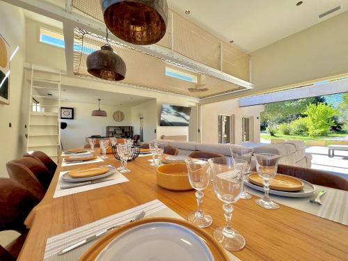 - une salle à manger avec une table et des verres à vin dans l'établissement L’Étoile de Dan, Piscine, Spa & Jeux, à Crespian