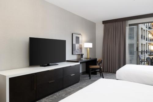 a hotel room with a television and a bed at Hilton Promenade Branson Landing in Branson