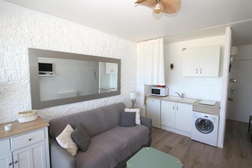 Il comprend un salon doté d'un canapé et une cuisine équipée d'un évier. dans l'établissement magnifique studio vue mer, à Canet