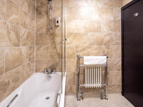 a bathroom with a bath tub and a shower at The Black Boy Inn in Caernarfon