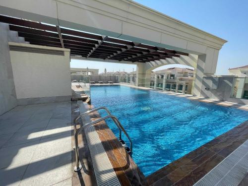 a swimming pool with a bench on a building at OYO HOME 1382 Spacious 1 BHK With Balcony in Abu Dhabi