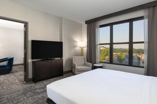 a hotel room with a bed and a flat screen tv at Hilton Promenade Branson Landing in Branson