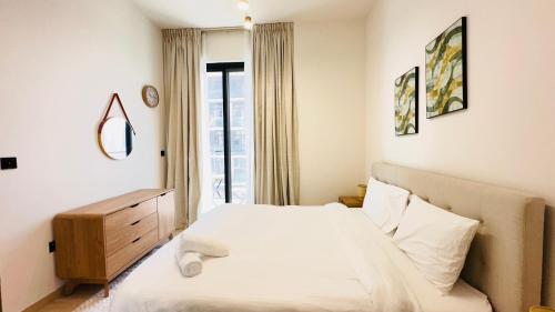 a bedroom with a white bed and a window at OYO 1291 Home Fully Furnished 1bed Apt @JVC in Dubai