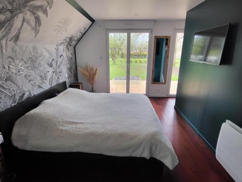 - une chambre avec un grand lit blanc et une porte coulissante en verre dans l'établissement Maison moderne 180 m2, à 10 min du Circuit des 24h du Mans, à Fatines