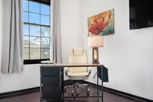an office with a desk with a chair and a lamp at Charming Elegance Getaway in Omaha