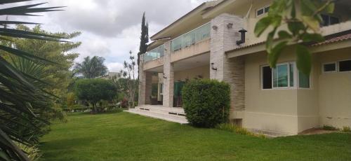 a house with a green lawn in front of it at Casa para locação por temporada, Gravatá, Pernambuco in Gravatá