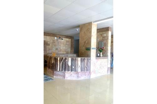 a lobby of a building with a stone wall at OYO 157 Dream Barka Hotel in Barka