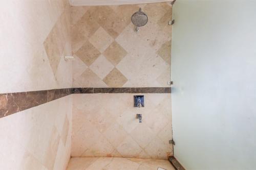 a shower in a bathroom with a tile wall at OYO 154 Bait AL Marmar Hotel in Sohar