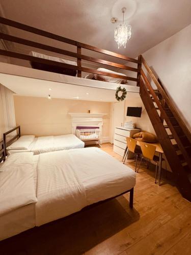 a large bedroom with two beds and a desk at Anwar House in London