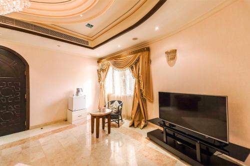 a living room with a large flat screen tv at OYO 154 Bait AL Marmar Hotel in Sohar