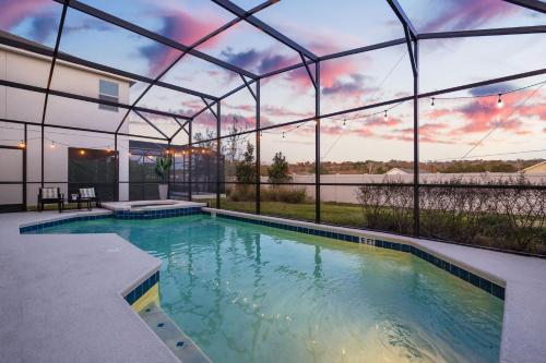 an indoor swimming pool in a house with a building at Upstay Vibrant Home w Themed Rooms Pool & Games in Kissimmee