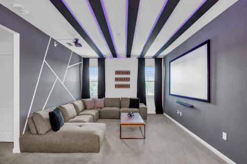 a living room with a couch and a tv at Upstay Vibrant Home w Themed Rooms Pool & Games in Kissimmee