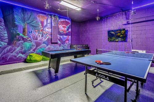 two ping pong tables in a room with a mural at Upstay Vibrant Home w Themed Rooms Pool & Games in Kissimmee