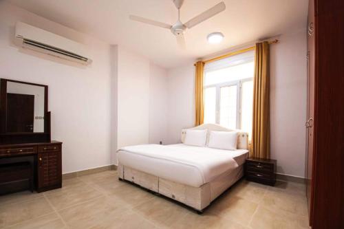 a bedroom with a white bed and a window at Super OYO 145 Jandul Salalah 2 Furnished Apartment in Salalah