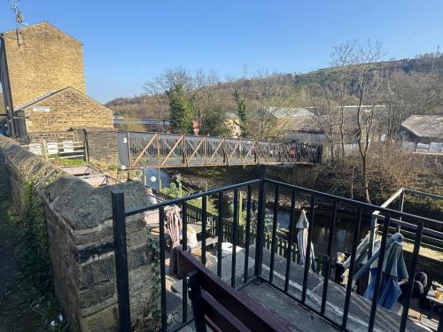 a bridge over a river next to a fence at Sowerby Apartment in Sowerby Bridge