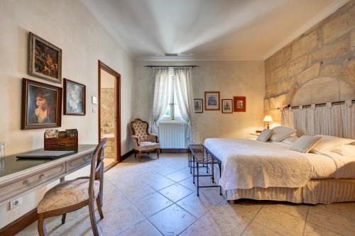 a bedroom with a large bed and a desk and chair at Mas des Comtes de Provence in Tarascon
