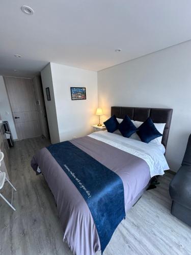 una camera da letto con un letto grande con cuscini blu di Your ideal space in Bogota a Bogotá