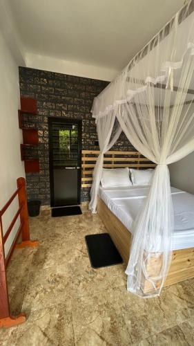 a bedroom with a bed with a mosquito net at Mountain Shack Homestay in Ella