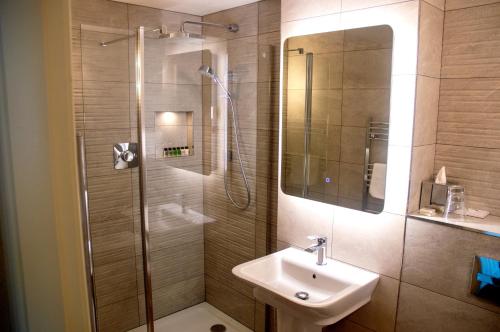 a bathroom with a sink and a shower at Holly Tree Hotel, Swimming Pool & Hot Tub in Glencoe