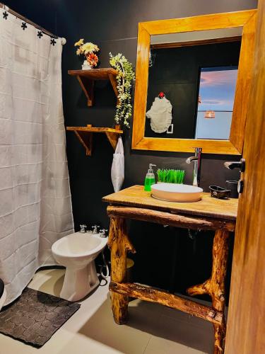 a bathroom with a sink and a mirror and a toilet at Depto CENTRICO AURA in Río Gallegos