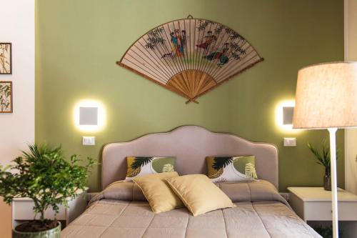una camera da letto con un letto e un ventilatore a muro di Tetide Home a Palermo