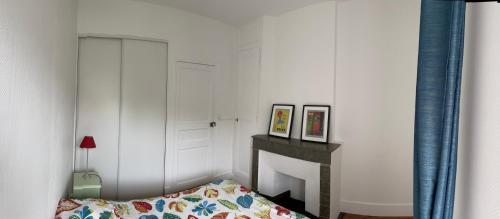 une chambre avec un lit et un mur blanc dans l'établissement Appartement collonges bord de Saône, à Collonges-au-Mont-dʼOr