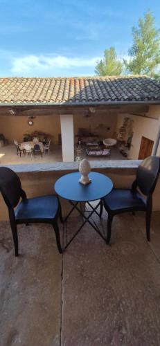une terrasse avec 2 chaises et une table ainsi qu'une maison dans l'établissement Le Mas des Rosiers, à Saint-Martin-Laguépie