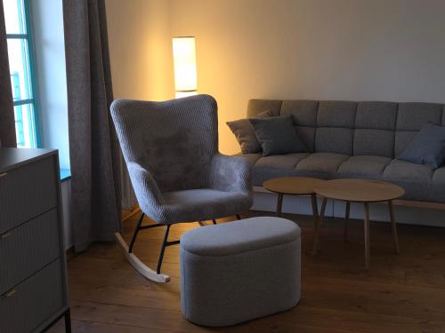 a living room with a chair and a couch at Homutův statek in Kokořín