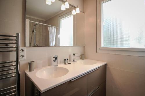 une salle de bain avec un lavabo, un miroir et une fenêtre dans l'établissement CHENES Lumineux Vue Mer Clim Confort Terrasses Parking, à Antibes