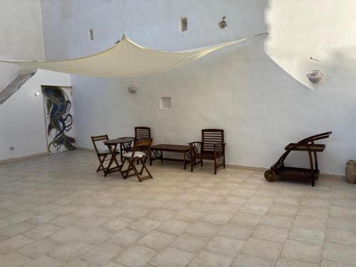 a room with wooden chairs and tables and a wall at Don Nicola Tourist Location in Polignano a Mare