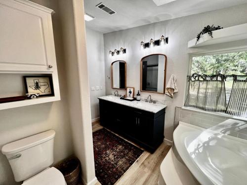 a bathroom with a sink and a tub and a toilet at The Pine Tree Palace in Bastrop