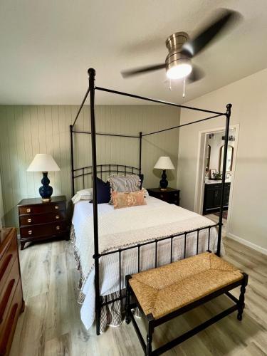 a bedroom with a black canopy bed with a fan at The Pine Tree Palace in Bastrop