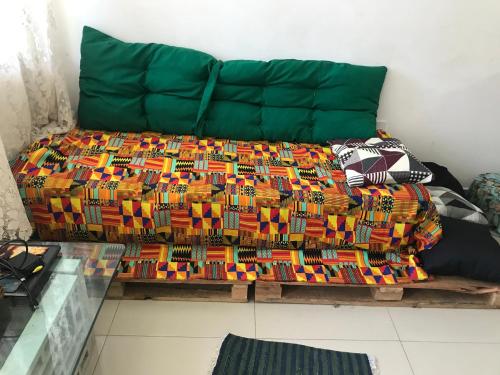 a bed with a colorful blanket on top of it at Espaço Baobá Suítes Confortáveis in Camboriú