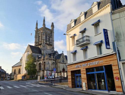 an old building and a church with a clock tower at Hotel Vent d'Ouest in Fécamp