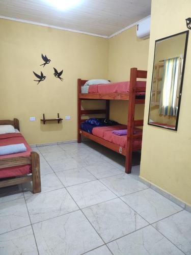 a room with two bunk beds and a mirror at Nomads Hostel in Puerto Iguazú