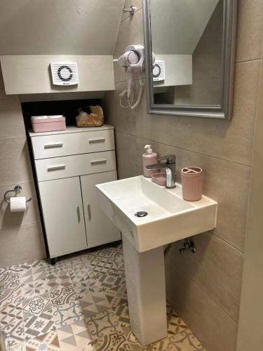 a bathroom with a white sink and a mirror at Petra Home Pyrgi in Chios