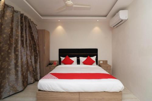 a bedroom with a large bed with red pillows at Grace Residency in Puducherry Airpoert