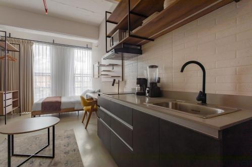 a kitchen with a sink and a bed in a room at Atelier Ivin 567 in Bogotá