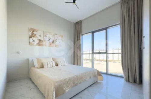 un dormitorio blanco con una cama y una ventana grande en B&B retro, en Dubái