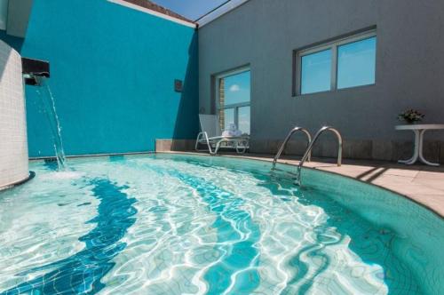 a large swimming pool with a blue wall at Perdizes Flats in Sao Paulo