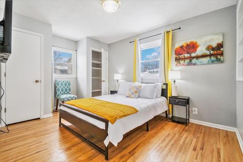 Un dormitorio con una cama y dos ventanas. en Modern 4-Bedroom Retreat, en Omaha