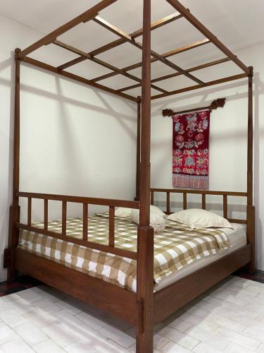 a bedroom with a wooden bed with a wooden frame at Joglo House in Central Bogor By penggemarlawas in Bogor