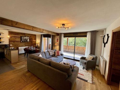 un salon avec un canapé et des chaises et une cuisine dans l'établissement Grand T4 lumineux en plein coeur de Châtel - Multipass inclu, à Châtel