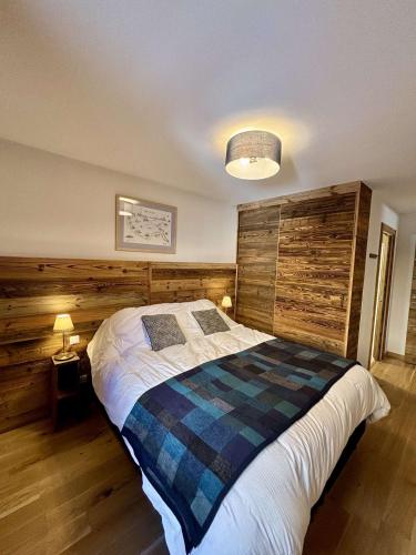une chambre avec un lit et un mur en bois dans l'établissement Grand T4 lumineux en plein coeur de Châtel - Multipass inclu, à Châtel
