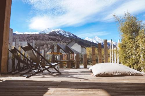 a patio with a bed and mountains in the background at Le petit Repaire de Sailhan, Ecolodges in Sailhan